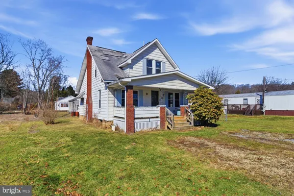 a view of a house with a yard and sitting area