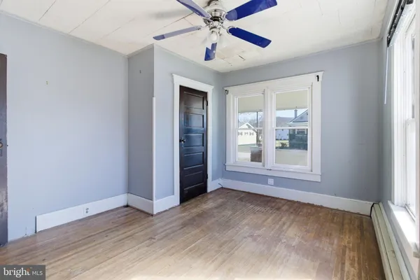 an empty room with fan and windows
