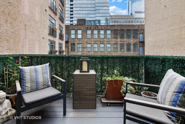 a view of a roof deck with wooden fence and a couch