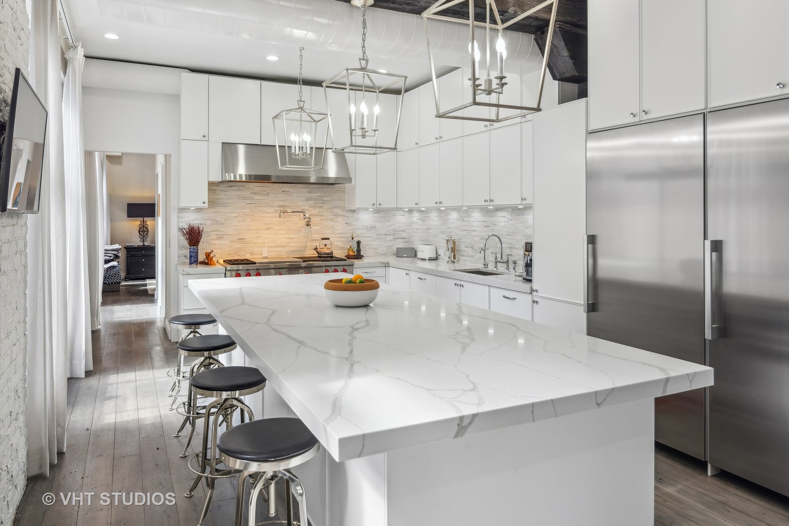 215 West Illinois Street, Unit 3A Chicago, IL 60654 - Photo 8 of 18 a kitchen with stainless steel appliances kitchen island a table chairs in it and wooden floors