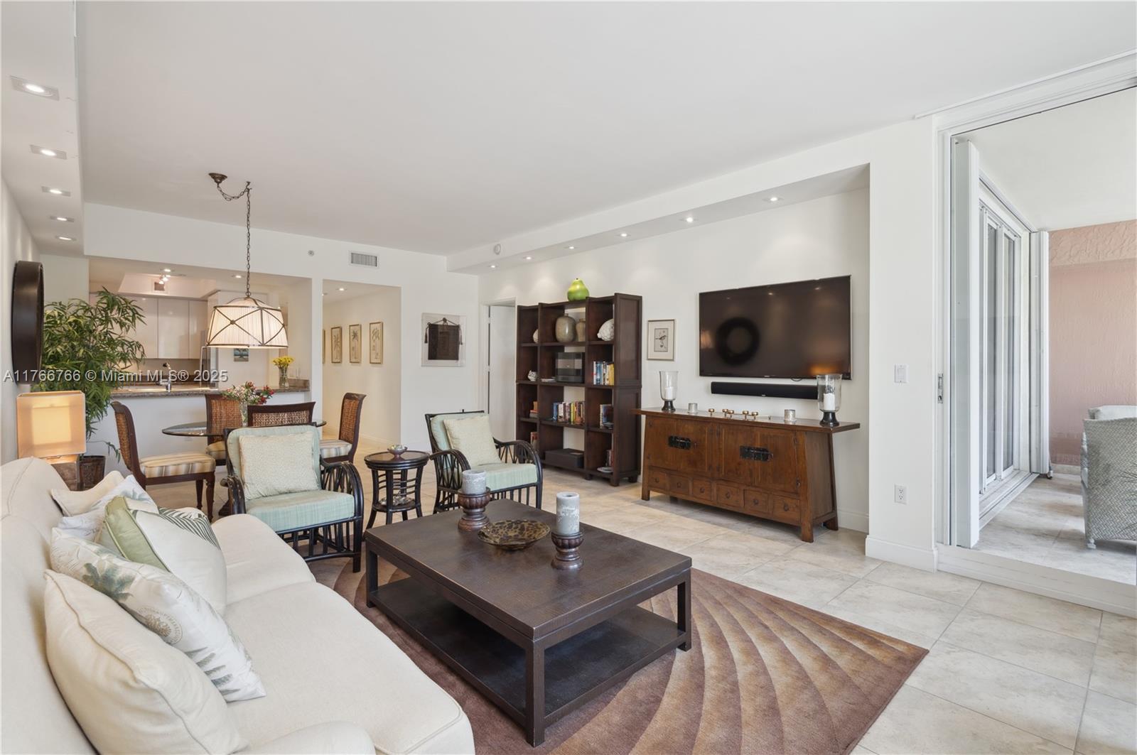 765 Crandon Boulevard, Unit 111 Key Biscayne, FL 33149 - Photo 8 of 57 a living room with furniture and a flat screen tv