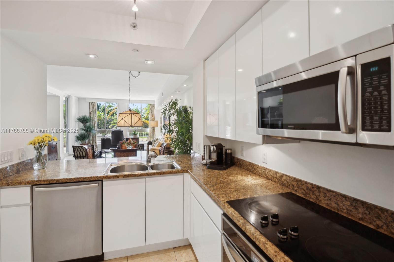 765 Crandon Boulevard, Unit 111 Key Biscayne, FL 33149 - Photo 10 of 57 a kitchen with stainless steel appliances granite countertop a sink and a microwave