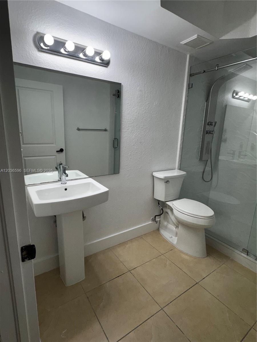 2301 Southwest 27th Avenue, Unit 503 Miami, FL 33145 - Photo 16 of 24 a bathroom with a sink toilet and a mirror