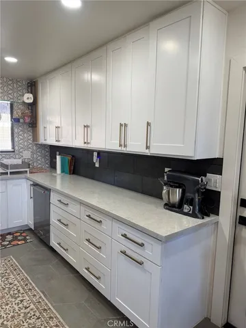 a kitchen with granite countertop white cabinets and sink