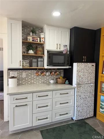 a kitchen with granite countertop cabinets and refrigerator
