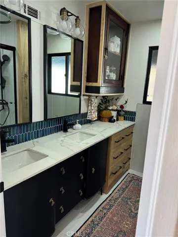a bathroom with a double vanity sink and a mirror