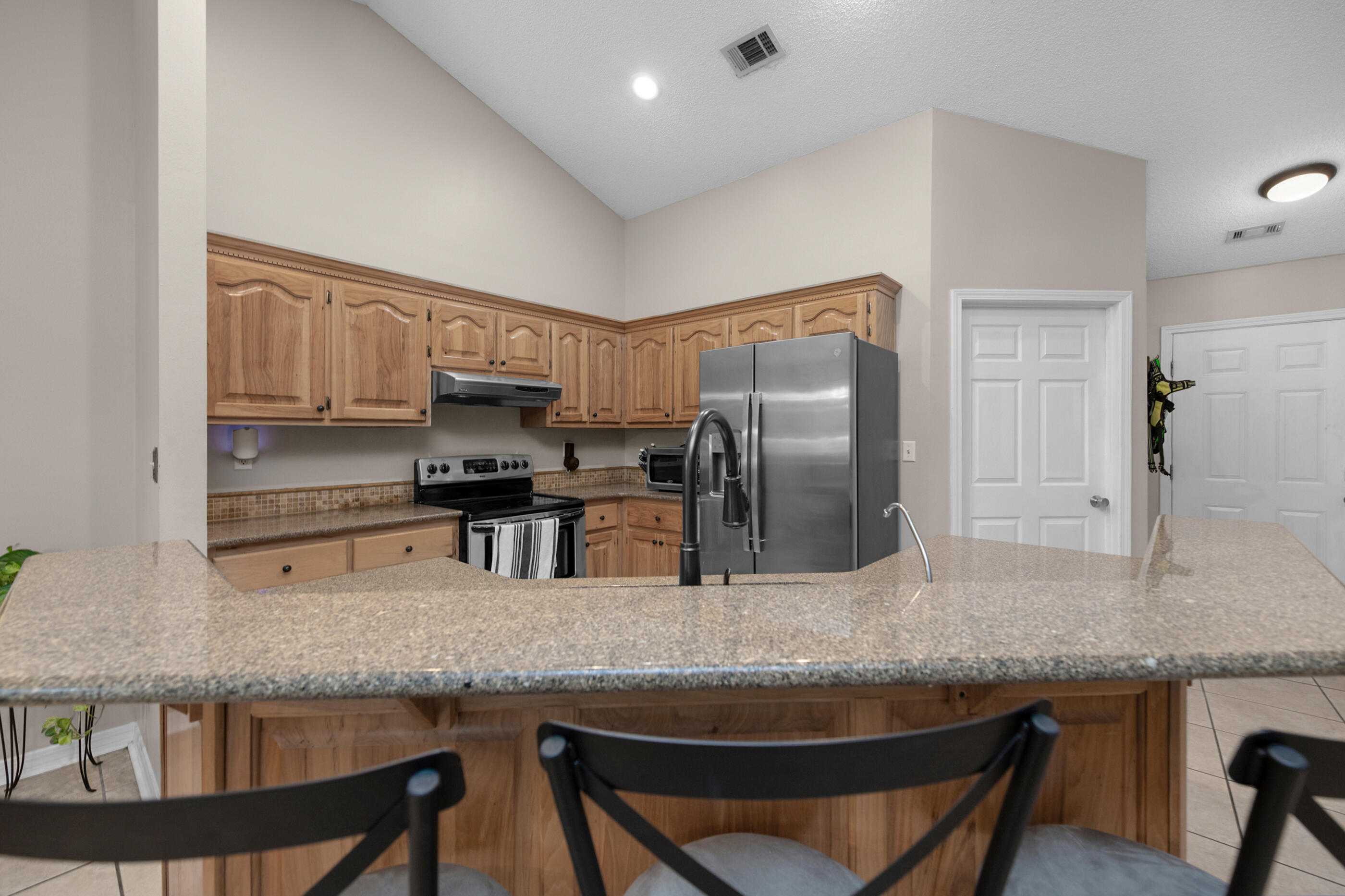 4439 Antioch Road Crestview, FL 32536 - Photo 6 of 32 a kitchen with granite countertop a refrigerator a stove and a sink