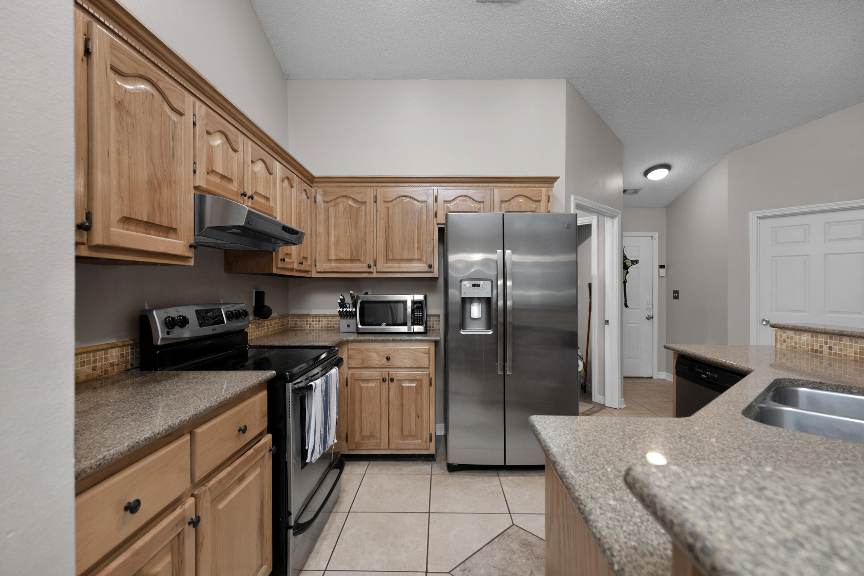 4439 Antioch Road Crestview, FL 32536 - Photo 7 of 32 a kitchen with stainless steel appliances granite countertop a sink a stove a refrigerator a washer and dryer