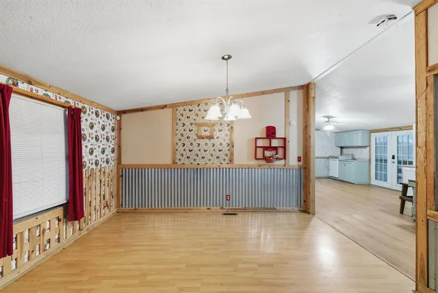 an empty room with ceiling fan and windows