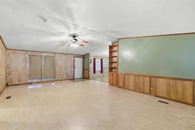 an empty room with windows and fireplace