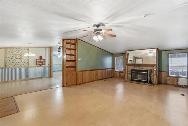 a view of an empty room with a fireplace and a window