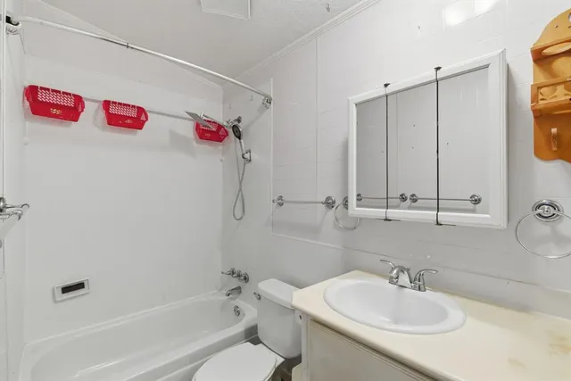 a view of an empty room with window and chandelier fan
