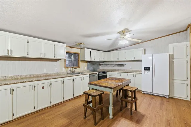 a kitchen with stainless steel appliances granite countertop a sink and cabinets