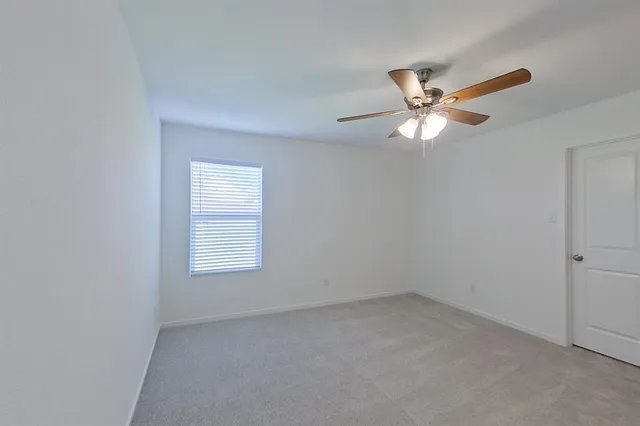 an empty room with a window and a fan