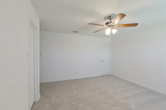 an empty room with a window and a fan
