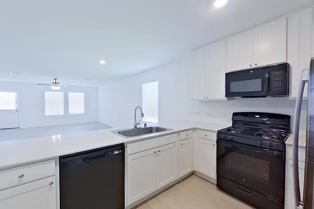 a kitchen with a sink stove and microwave