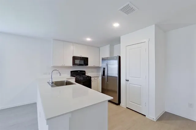 a kitchen with stainless steel appliances a refrigerator sink and microwave
