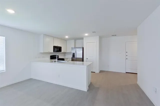 a view of kitchen with stainless steel appliances refrigerator and microwave