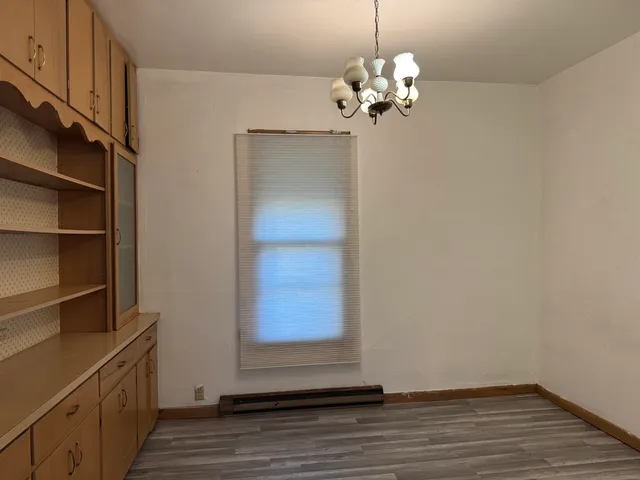 a view of a room with wooden floor and chandelier