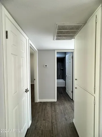 a view of a hallway with wooden floor and a ceiling fan