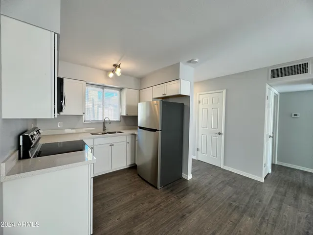 a kitchen with a refrigerator sink and cabinets