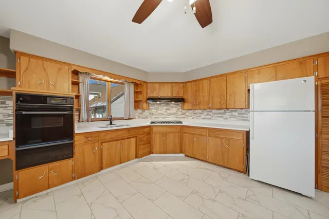 a kitchen with granite countertop a refrigerator and a sink