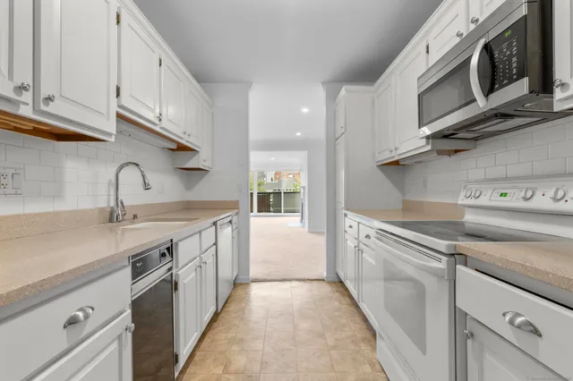 a kitchen with stainless steel appliances granite countertop a sink and a stove