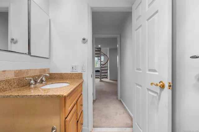 a bathroom with a granite countertop sink and a mirror