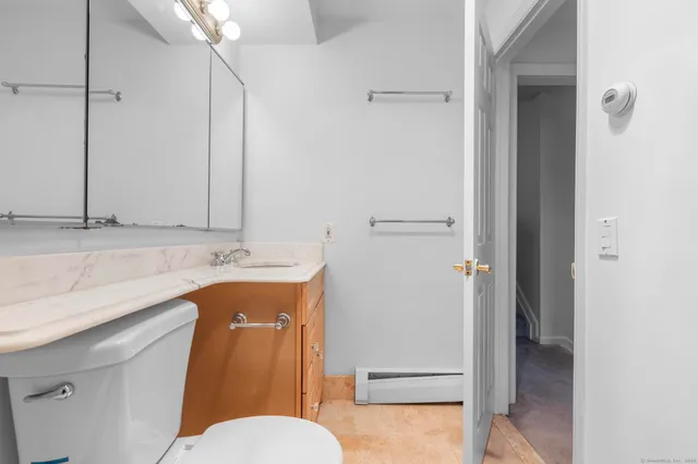 a bathroom with a granite countertop sink mirror vanity and toilet