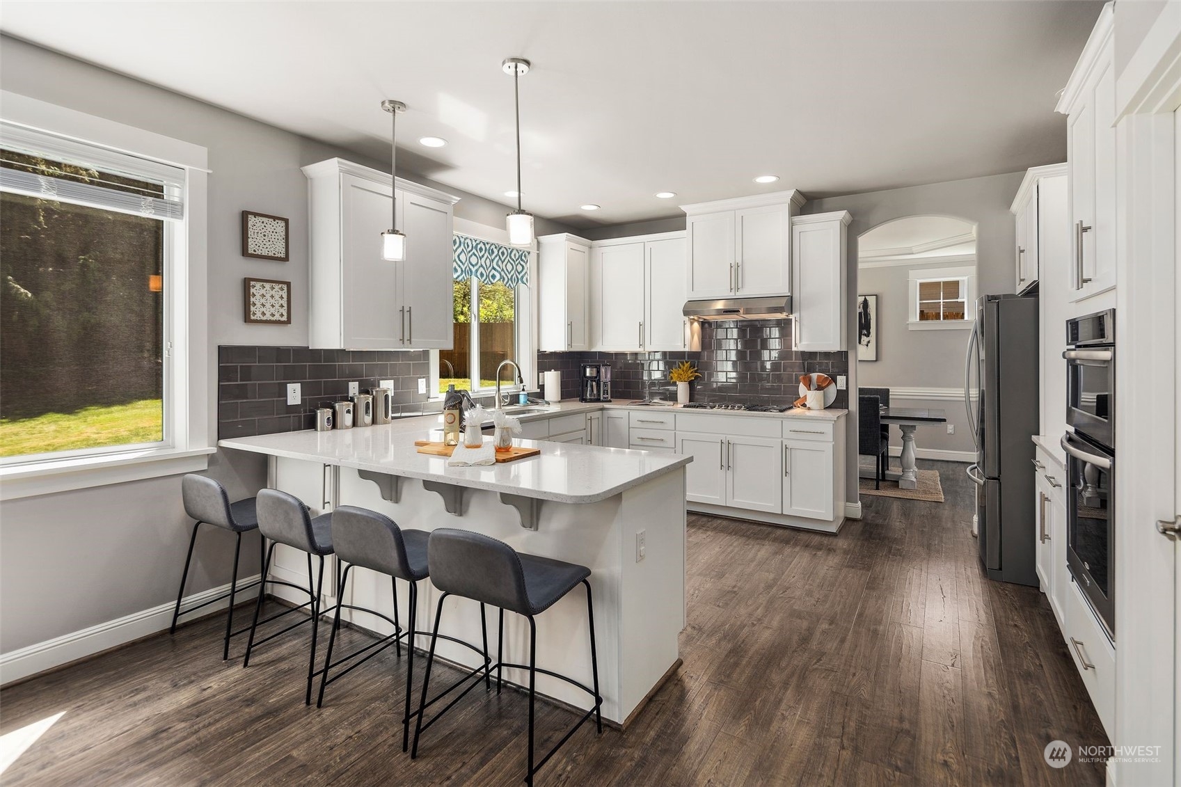 22817 Barker Road Bothell, WA 98021 - Photo 12 of 40 a kitchen with stainless steel appliances a dining table chairs stove refrigerator and cabinets