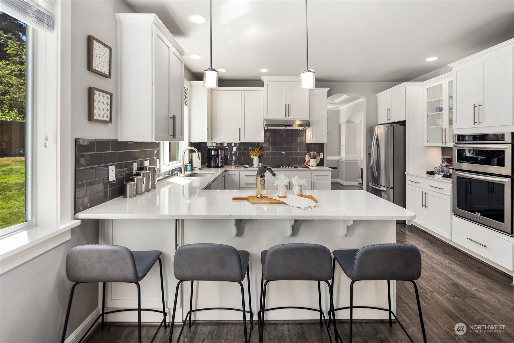 22817 Barker Road Bothell, WA 98021 - Photo 16 of 40 a kitchen with stainless steel appliances kitchen island granite countertop a table chairs and a refrigerator