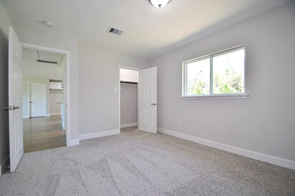 an empty room with windows and closet