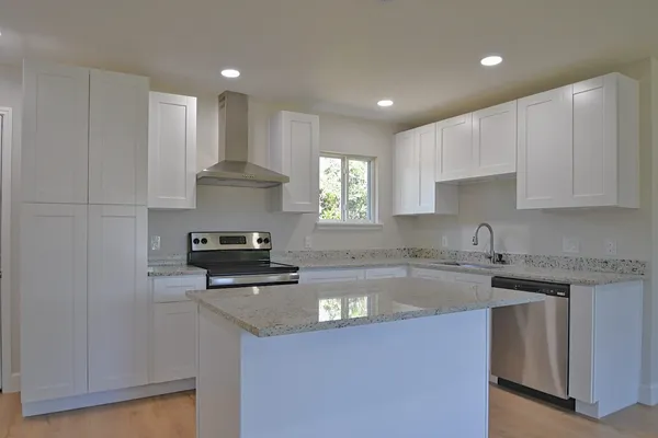 a kitchen with a sink a stove and cabinets