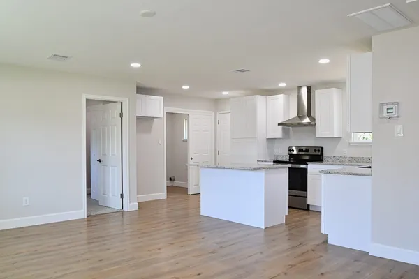 a kitchen with stainless steel appliances granite countertop a refrigerator and a stove top oven