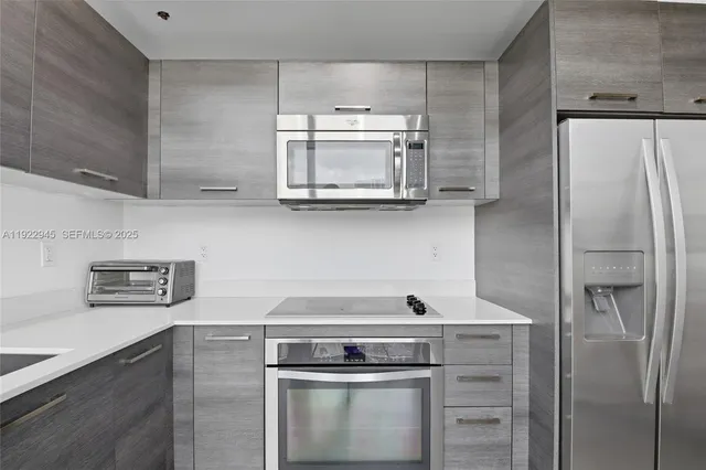 a kitchen with stainless steel appliances a refrigerator and a stove top oven