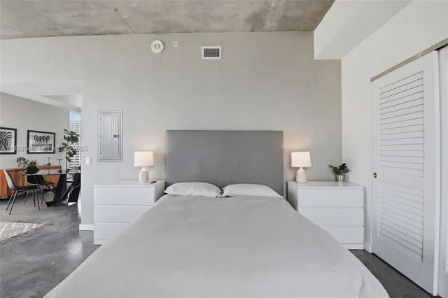 a bedroom with a white bed and white cabinets