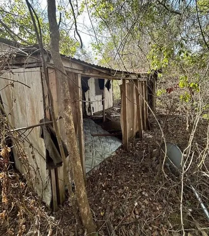 a view of a house with backyard and trees