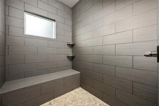 a spacious bathroom with a granite countertop double vanity and a mirror