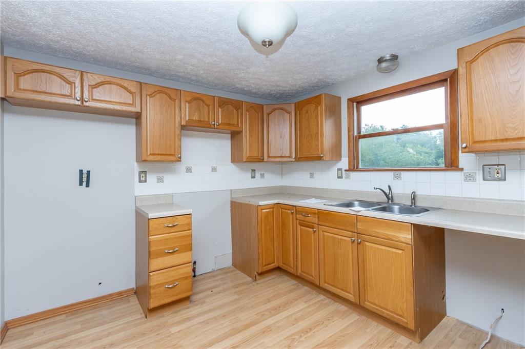 634 Bairdford Road Gibsonia, PA 15044 - Photo 10 of 23 a kitchen with stainless steel appliances granite countertop a sink and cabinets with wooden floor