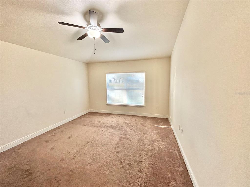 13231 Precept Way Hudson, FL 34669 - Photo 15 of 30 an empty room with a window and a ceiling fan