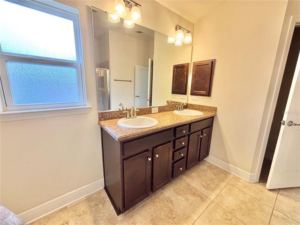 13231 Precept Way Hudson, FL 34669 - Photo 23 of 30 a bathroom with a double vanity sink a and mirror