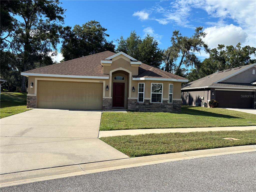13231 Precept Way Hudson, FL 34669 - Photo 30 of 30 a front view of a house with a garden and trees
