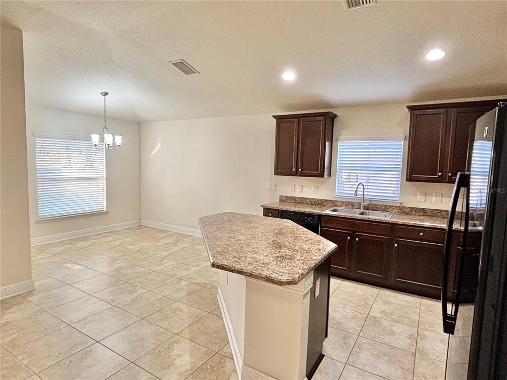 13231 Precept Way Hudson, FL 34669 - Photo 9 of 30 a kitchen with a sink refrigerator and cabinets