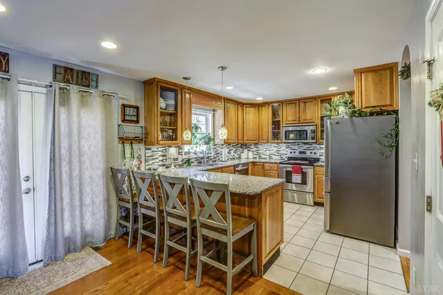 a kitchen with stainless steel appliances granite countertop a sink and a refrigerator