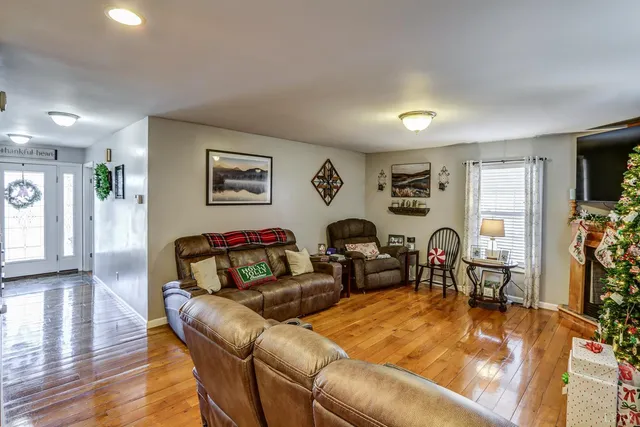 a view of a hallway with wooden floor and living room