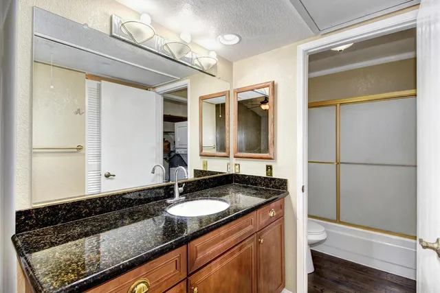 a bathroom with a granite countertop sink and a mirror
