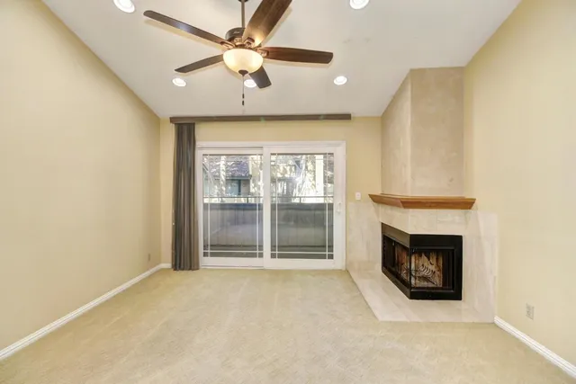view of an empty room with a fireplace and a window