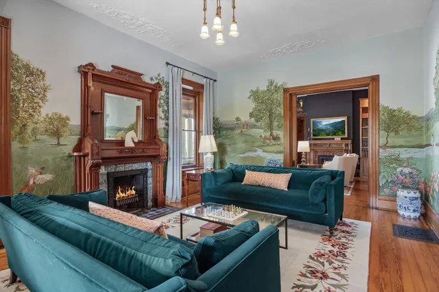 a kitchen with stainless steel appliances granite countertop a refrigerator a sink dishwasher a stove and a dining table with wooden floor