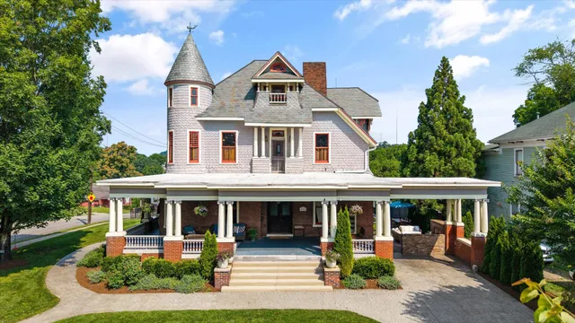 a front view of a house with a yard and trees