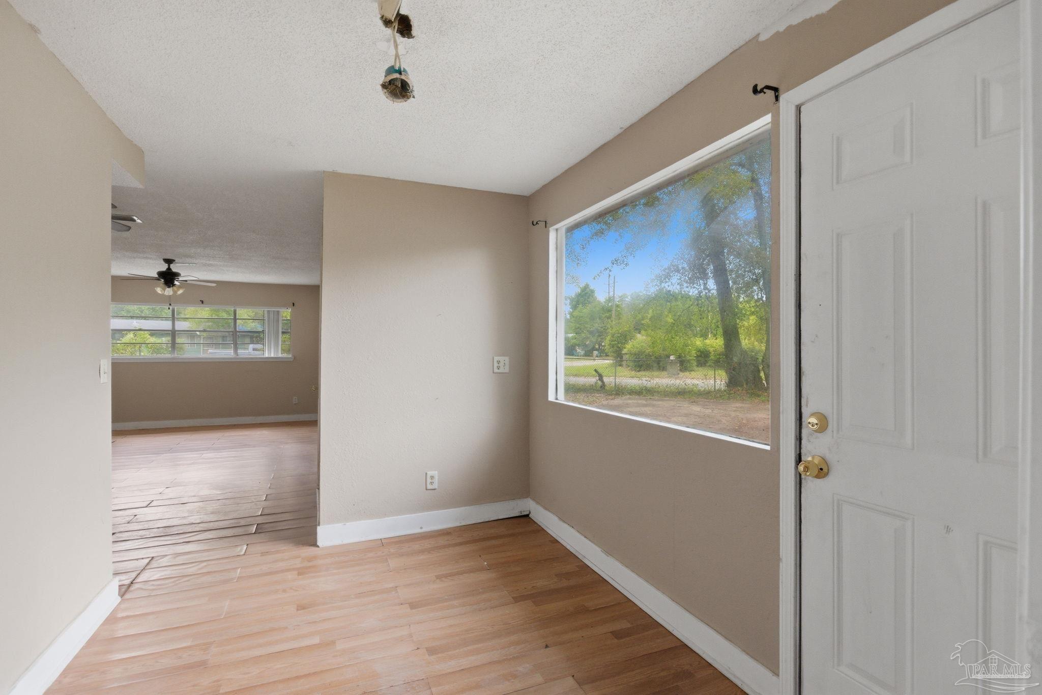 4482 Rochelle Drive Pensacola, FL 32505 - Photo 5 of 30 a view of hallway with a large window and wooden floor